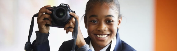 Student with a camera during a Photography lesson