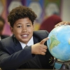 Student pointing to a location on a globe